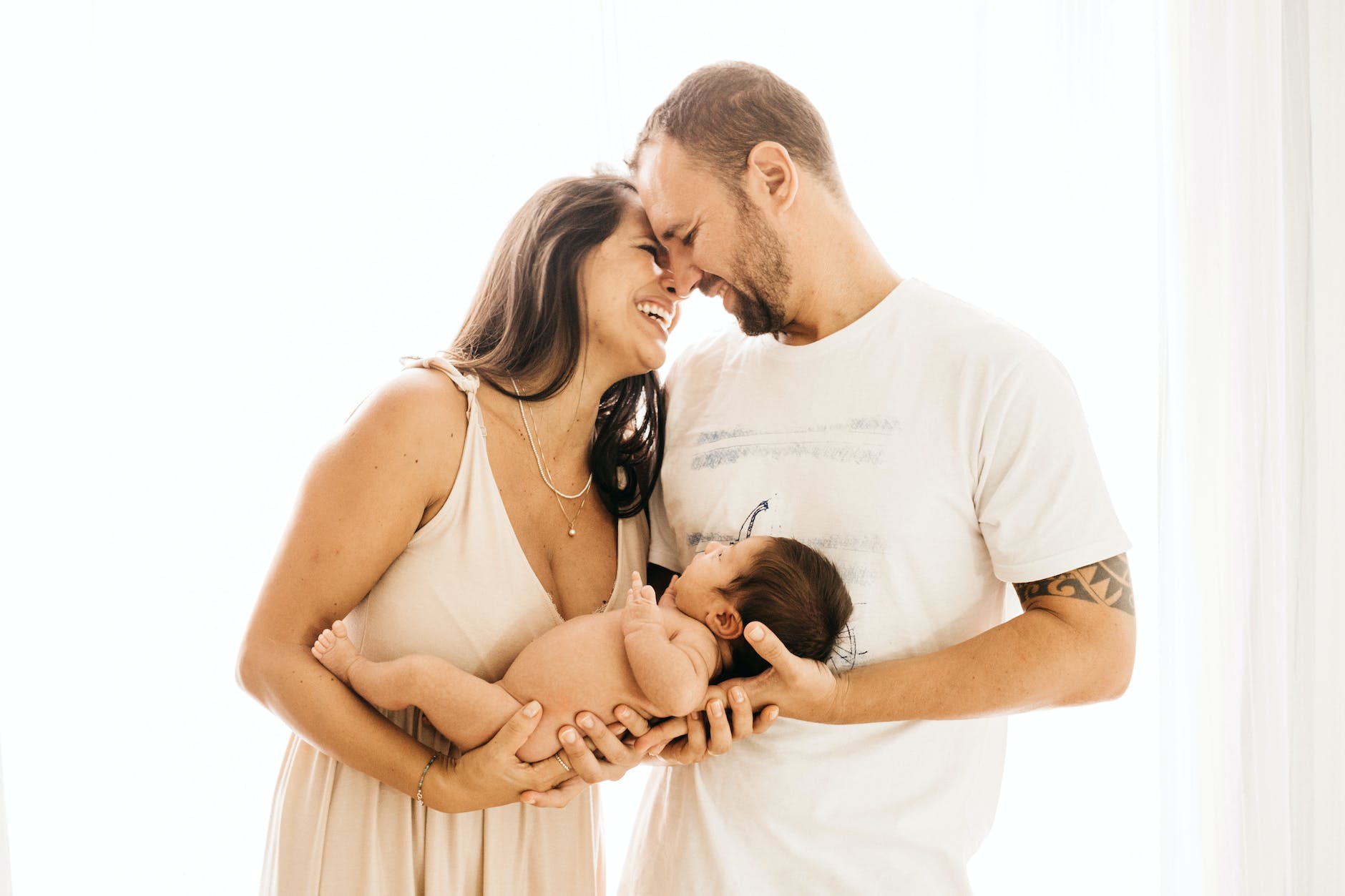 photo of laughing couple carrying a baby